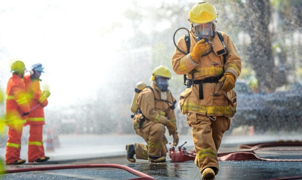 Firemen in gear with hoses